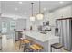 Open kitchen features stainless steel appliances, island with seating, and hardwood floors throughout at 136 Rowans Creek Dr, Charleston, SC 29492