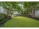 Serene backyard with green turf, landscaping, and mature shade trees at 1407 Wando View St, Daniel Island, SC 29492