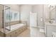 Bright bathroom with a soaking tub, tiled floors, large windows, and a double sink vanity at 1407 Wando View St, Daniel Island, SC 29492