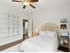 Bright bedroom with a white rug, ceiling fan, decorative headboard and wall shelves at 1407 Wando View St, Daniel Island, SC 29492