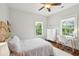 Bright bedroom features a ceiling fan, two windows, a desk, and a white dresser at 1407 Wando View St, Daniel Island, SC 29492