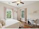 Bright bedroom featuring hardwood floors, two windows, and a work space with a modern desk at 1407 Wando View St, Daniel Island, SC 29492
