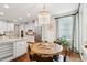 Open dining area boasts a wood table, chandelier, and view into the kitchen and stainless appliances at 1407 Wando View St, Daniel Island, SC 29492