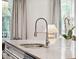 Bright kitchen featuring granite countertops, modern steel faucet, and white cabinetry at 1407 Wando View St, Daniel Island, SC 29492