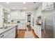 Clean white kitchen with stainless steel appliances and access to dining and living area at 1407 Wando View St, Daniel Island, SC 29492