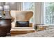 A sunny reading nook in the main bedroom features a comfortable chair with a footstool and table at 1407 Wando View St, Daniel Island, SC 29492