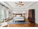 Spacious main bedroom with tray ceilings, ceiling fan, wood floors, and sitting area at 1407 Wando View St, Daniel Island, SC 29492