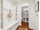 Stylish mudroom features seating with storage, with a powder room with patterned wallpaper nearby at 1407 Wando View St, Daniel Island, SC 29492