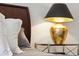 Nightstand with bedside lamp with ornate gold base, sitting next to the bed and pillows at 1407 Wando View St, Daniel Island, SC 29492