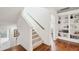 Staircase with wood handrail leads to the next floor and adjacent built-in shelves at 1407 Wando View St, Daniel Island, SC 29492