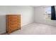 Bright bedroom features neutral carpet, a window for natural light, and a wooden dresser at 141 Lagoona Dr, Summerville, SC 29483