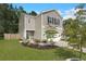 View of a two-story home featuring a well-manicured lawn, tasteful landscaping, and a concrete driveway at 141 Lagoona Dr, Summerville, SC 29483