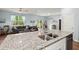 Open kitchen with granite countertops, stainless steel sink, and an adjoining living space with a gray sectional at 141 Lagoona Dr, Summerville, SC 29483