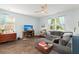 Bright living room with a ceiling fan, wood floors, a gray sectional couch, and a fireplace at 141 Lagoona Dr, Summerville, SC 29483