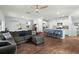 Open-concept living room and kitchen with wood floors, a gray sectional, ceiling fan, and kitchen island with bar stools at 141 Lagoona Dr, Summerville, SC 29483