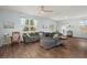 Bright living room with wood floors, a gray sectional, large windows with sheer curtains, and a ceiling fan at 141 Lagoona Dr, Summerville, SC 29483
