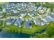 A high aerial view showcases a neighborhood community surrounded by lush greenery and serene ponds at 1439 Rivers Cotton Rd, Charleston, SC 29412