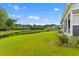 Expansive back yard with lush green lawn, tranquil pond, and a glimpse of the home's exterior at 1439 Rivers Cotton Rd, Charleston, SC 29412