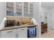 Modern bar area with built-in cabinets, wine cooler, backsplash, countertop, and decor at 1439 Rivers Cotton Rd, Charleston, SC 29412
