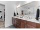 Bathroom featuring a double vanity with wood cabinets, white countertops and a large mirror at 1439 Rivers Cotton Rd, Charleston, SC 29412
