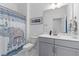 Bright bathroom with a gray vanity, toilet and a bathtub with a decorative elephant shower curtain at 1439 Rivers Cotton Rd, Charleston, SC 29412