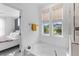 Bright bathroom featuring a soaking tub and large window overlooking the neighborhood at 1439 Rivers Cotton Rd, Charleston, SC 29412