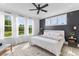 Spacious bedroom with hardwood floors, windows with sheer curtains, and dark accent wall behind the bed at 1439 Rivers Cotton Rd, Charleston, SC 29412