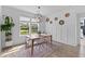 Bright dining area featuring wainscoting, decorative wall baskets, light wood floors, and large windows overlooking the lawn at 1439 Rivers Cotton Rd, Charleston, SC 29412