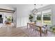 Dining room with wainscoting, wood table, views of the lawn, modern chandelier, and open access to other rooms at 1439 Rivers Cotton Rd, Charleston, SC 29412