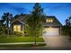 Charming gray home with illuminated windows, mature landscaping, and a two-car garage under a twilight sky at 1439 Rivers Cotton Rd, Charleston, SC 29412