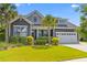 Charming gray two-story home with manicured lawn and tropical landscaping, with a convenient two-car garage at 1439 Rivers Cotton Rd, Charleston, SC 29412