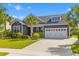 Well-maintained gray home with a manicured lawn, palm trees, and a two-car garage, exuding curb appeal at 1439 Rivers Cotton Rd, Charleston, SC 29412