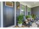 Inviting front porch with stylish Adirondack chairs, potted plants, and a modern front door at 1439 Rivers Cotton Rd, Charleston, SC 29412