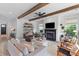 Inviting living room with exposed wood beams, a cozy fireplace, and comfortable seating arrangement at 1439 Rivers Cotton Rd, Charleston, SC 29412