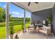 Covered patio features comfortable chairs and a scenic view of the landscaped backyard at 1439 Rivers Cotton Rd, Charleston, SC 29412