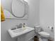 Stylish powder room with pedestal sink, custom mirror and toilet at 1439 Rivers Cotton Rd, Charleston, SC 29412