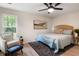 Cozy bedroom with a rattan headboard bed, accent chair, area rug, and a view of the surrounding yard at 1478 Diamond Blvd, Mount Pleasant, SC 29466