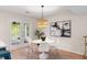 Elegant dining area with a modern light fixture, sleek furniture, and tranquil outdoor views at 1478 Diamond Blvd, Mount Pleasant, SC 29466