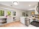 Open kitchen layout with stainless steel dishwasher, white cabinets, and natural light from large windows at 1478 Diamond Blvd, Mount Pleasant, SC 29466