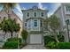 Charming three-story home with a light green exterior, a garage, and well-manicured landscaping at 1646 Marsh Harbor Ln, Mount Pleasant, SC 29464