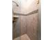 Luxurious tiled shower with a built-in shelf, and brass hardware accents at 1646 Marsh Harbor Ln, Mount Pleasant, SC 29464