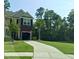 Charming two-story home with a brick accent, open garage, landscaped front yard, and long driveway at 1720 Restoration Ct, Charleston, SC 29414