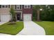 Charming two-story home with an open garage, landscaped front yard with an American flag, and long driveway at 1720 Restoration Ct, Charleston, SC 29414