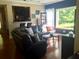 Comfortable living room with a cozy leather sofa, hardwood floors, and a large window overlooking nature at 1720 Restoration Ct, Charleston, SC 29414