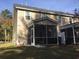 Back exterior of a two-story home with a screened-in porch and manicured lawn at 1720 Restoration Ct, Charleston, SC 29414