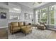 Comfortable living room with tan leather sofa set, neutral walls, and view to kitchen bar seating at 1735 Telfair Way, Charleston, SC 29412