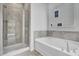 Modern bathroom showcasing a glass shower and soaking tub with neutral tile surround at 179 Threaded Fern St, Summerville, SC 29485