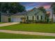 Charming one-story home with a well-manicured lawn and a two-car garage nestled amongst mature trees at 181 Sea Cotton Cir, Charleston, SC 29412