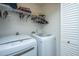 Functional laundry room featuring modern washer and dryer, complemented by overhead shelving for storage and organization at 181 Sea Cotton Cir, Charleston, SC 29412