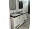 Modern bathroom featuring a double vanity with chrome faucets and dark countertops at 18441 Round O Rd, Round O, SC 29474